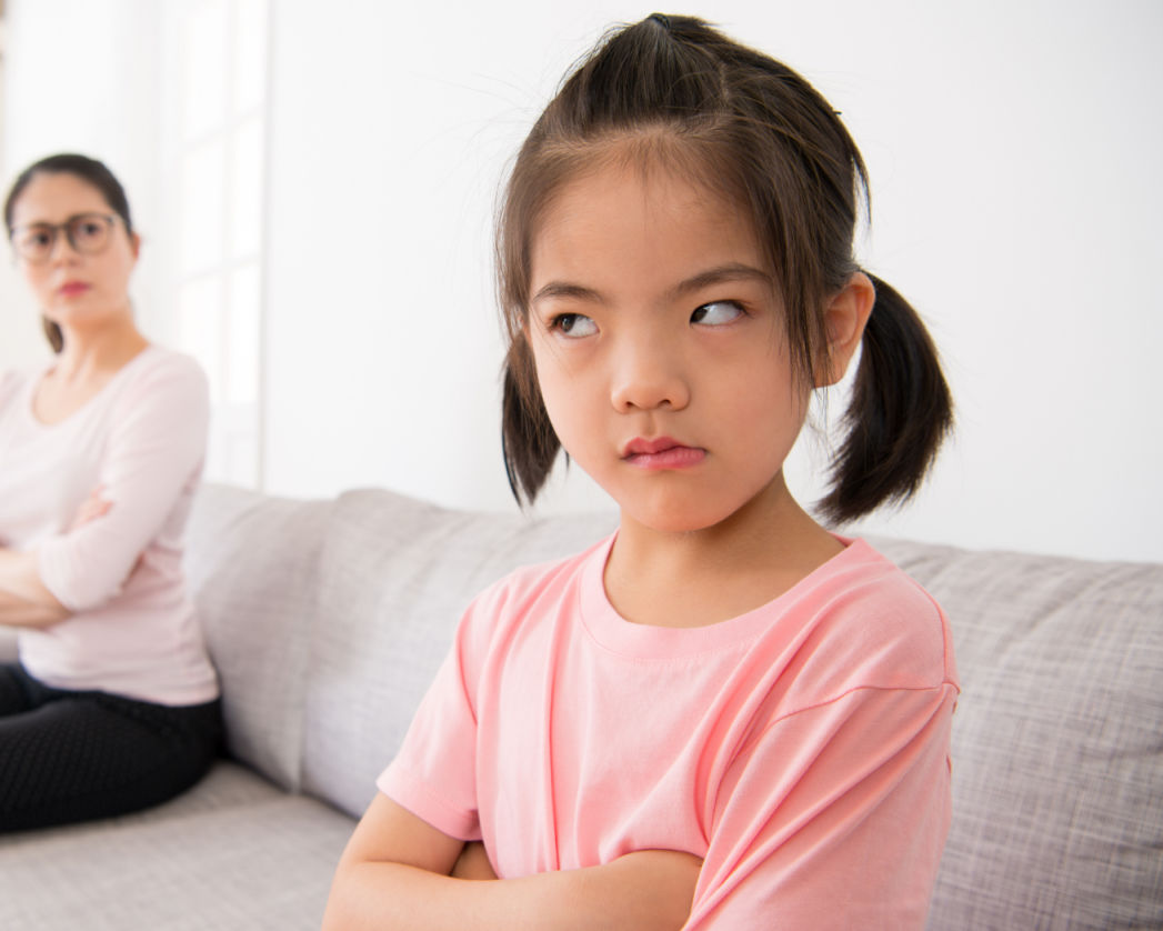 cute little girl does not want to care for her mother when her mother told her not to play must to going write homework then they confrontation sitting on the couch.