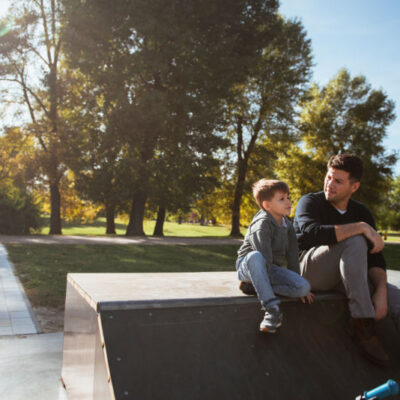 Father and son are sitting talking at a skate park - attachment theory explained