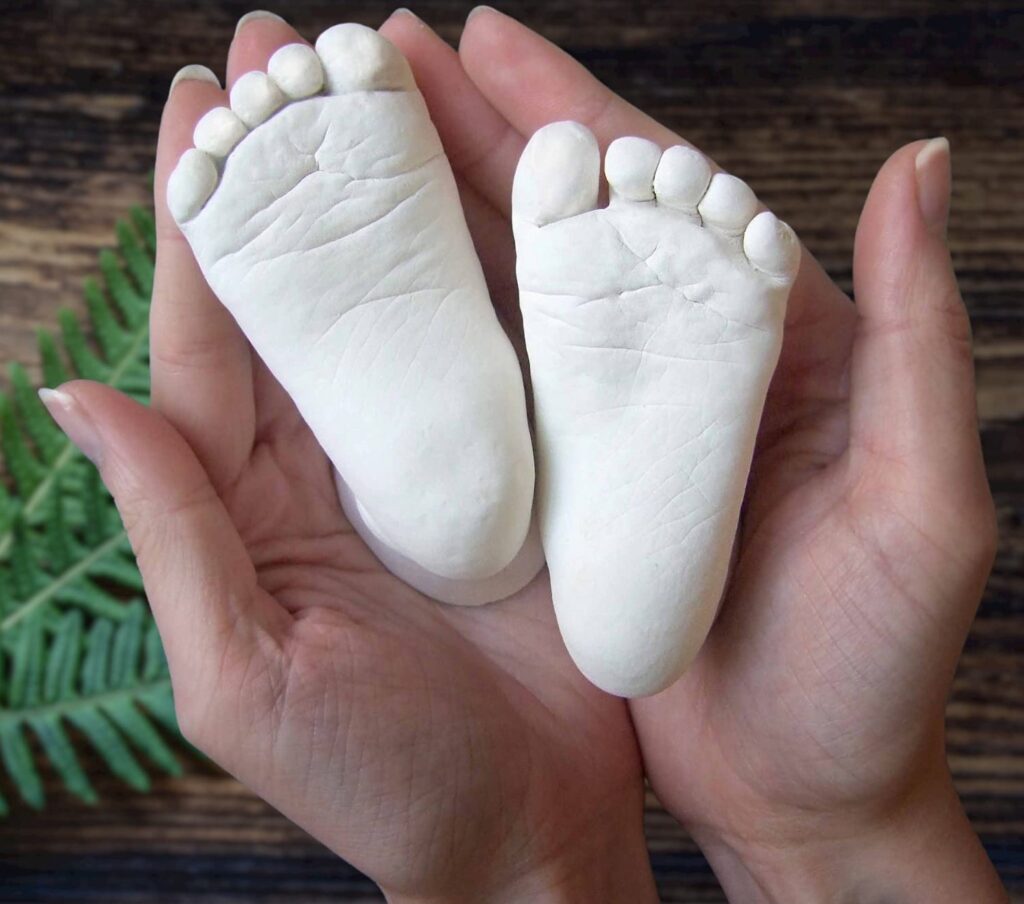 a cast of baby feet on top of two hands