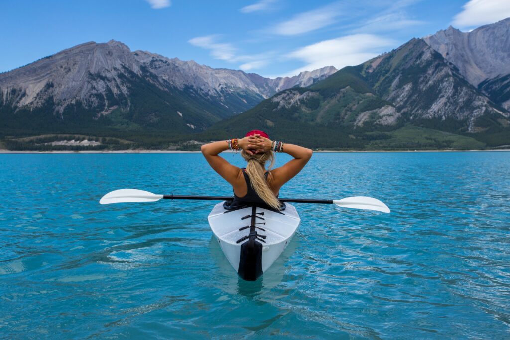 A good mom taking time for self-care and enjoying the view of the mountains in her kayak.