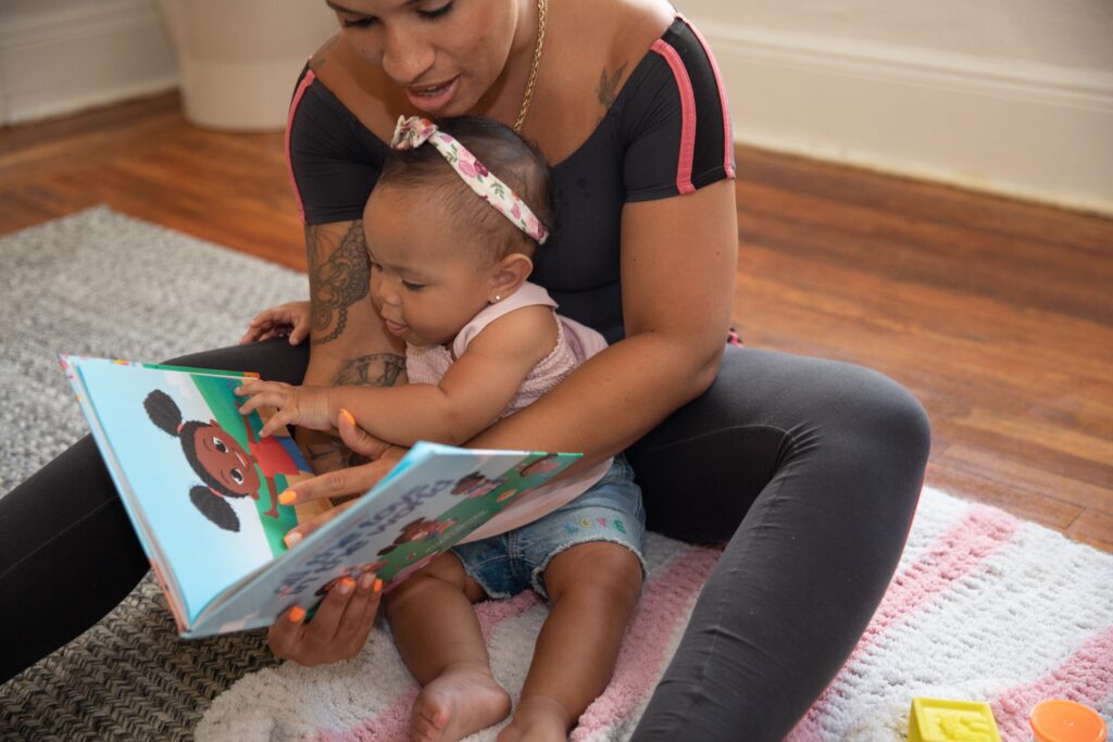 a mother reading a storybook to her baby