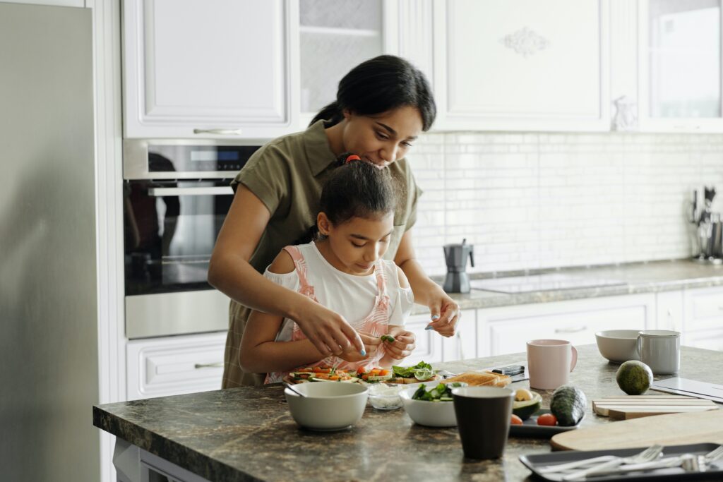 A child helps her mother prepare the meal, a great strategy for involving picky eaters.