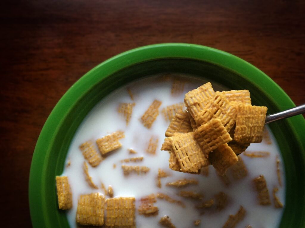 A green bowl filled with healthy cereal and milk.